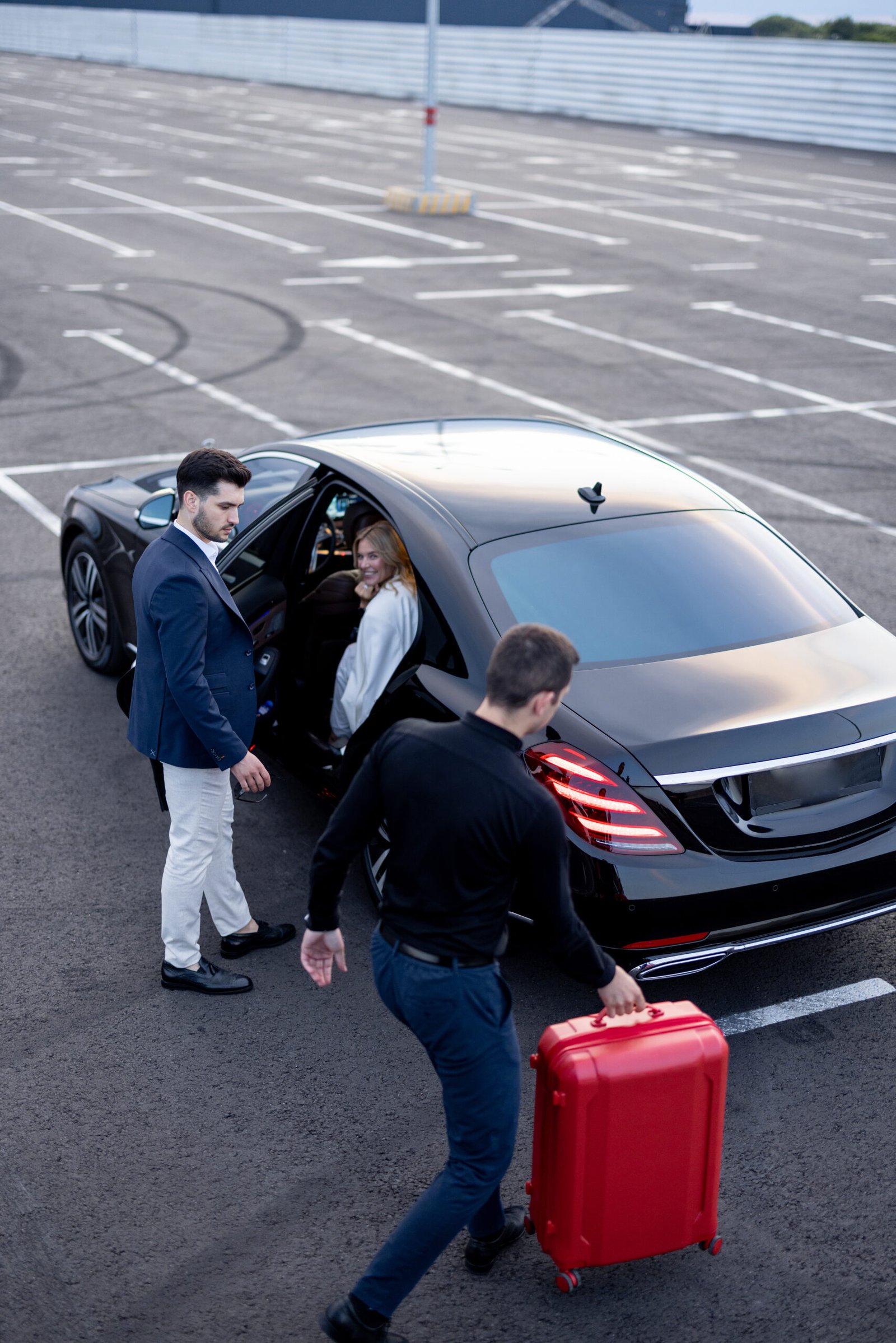 Business couple get in luxury taxi on parking lot