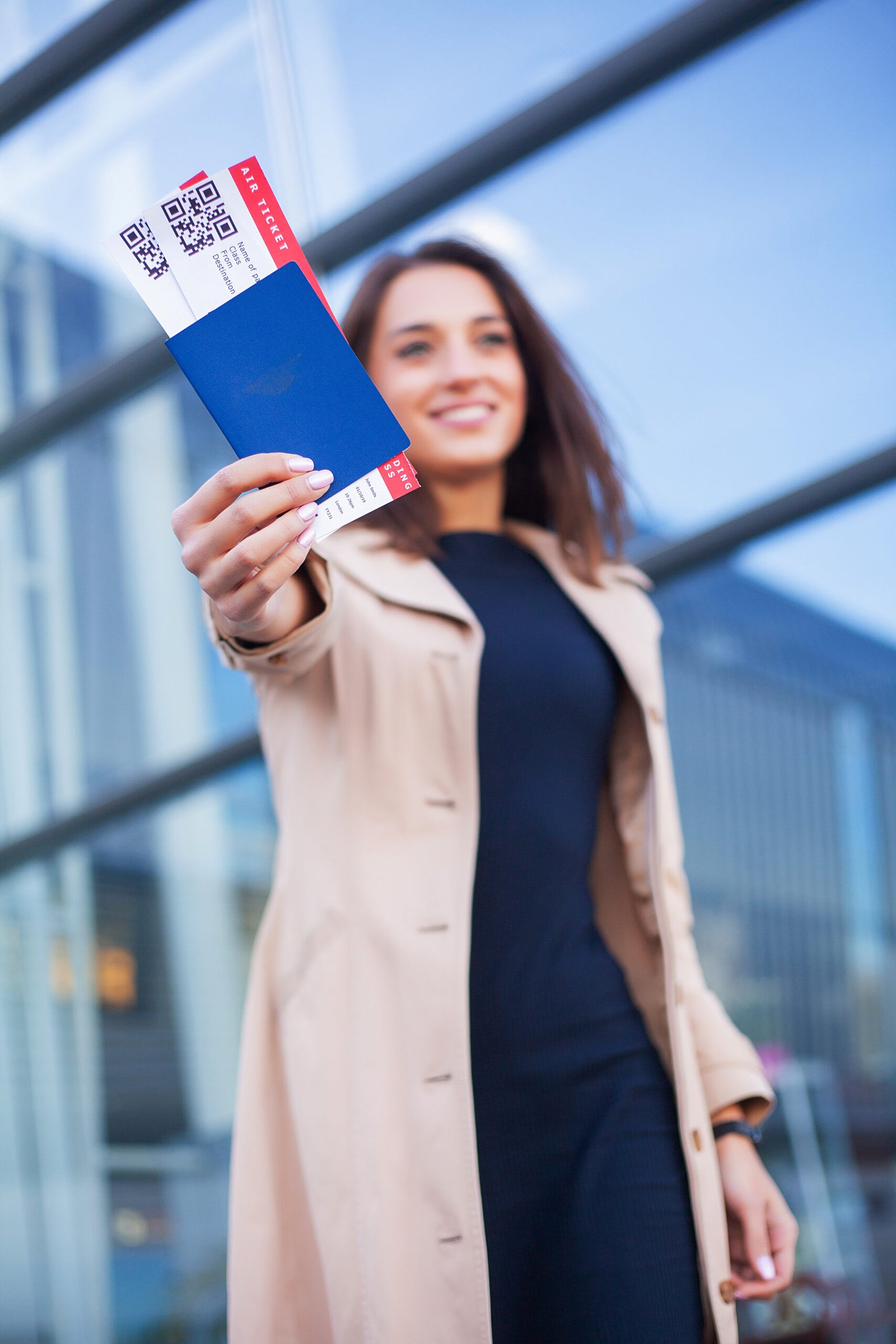 Woman holding two air ticket in abroad passport near airport